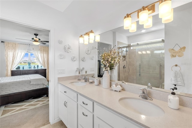 ensuite bathroom featuring ceiling fan, a stall shower, a sink, and double vanity