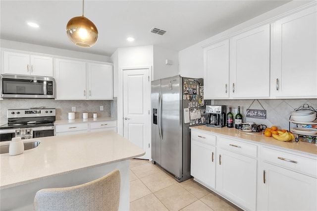 kitchen with light tile patterned floors, visible vents, white cabinetry, and stainless steel appliances