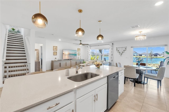 kitchen featuring a sink, open floor plan, hanging light fixtures, light countertops, and dishwasher