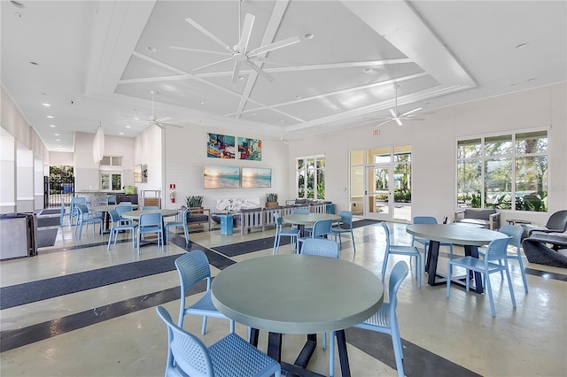 dining area featuring coffered ceiling, ceiling fan, finished concrete flooring, and a high ceiling