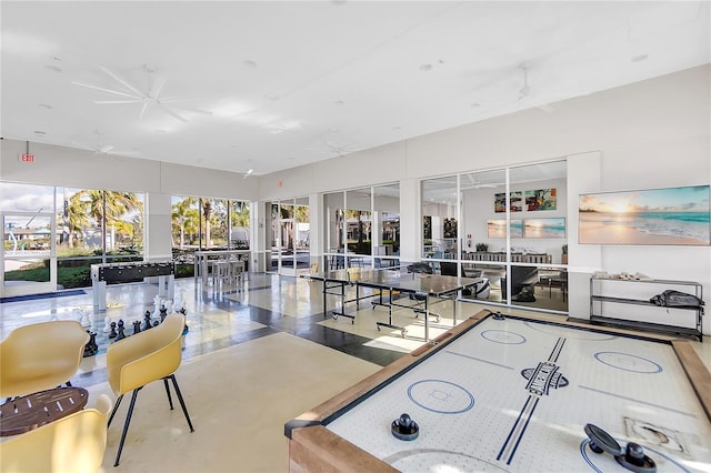 recreation room with concrete flooring and a ceiling fan