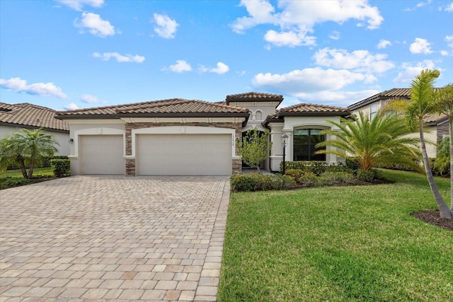 mediterranean / spanish-style house featuring a garage, a tile roof, decorative driveway, and a front yard