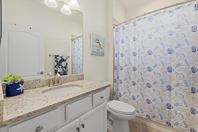 bathroom featuring toilet, a shower with shower curtain, and vanity