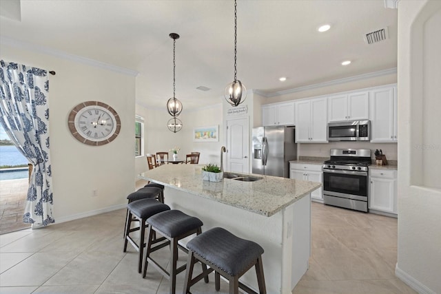 kitchen featuring visible vents, white cabinets, an island with sink, stainless steel appliances, and a sink