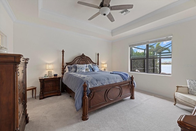 bedroom featuring light carpet, visible vents, a tray ceiling, and crown molding