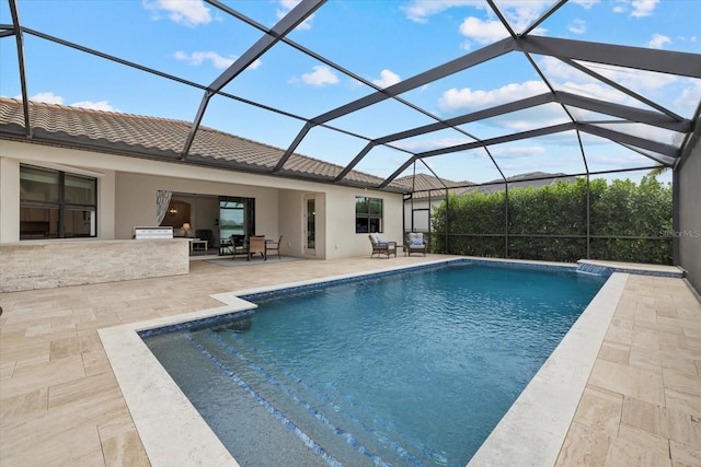 outdoor pool featuring a patio, exterior kitchen, and a lanai