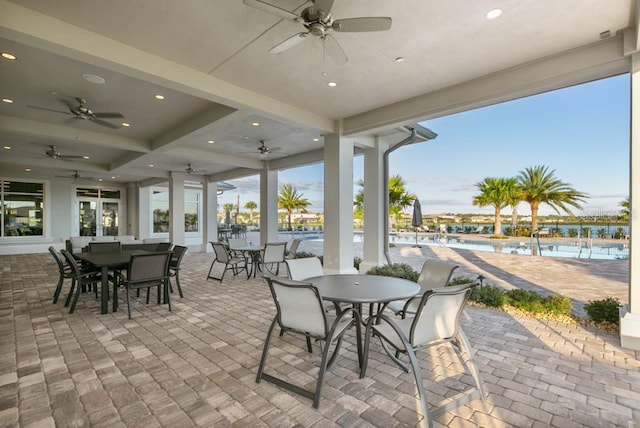 view of patio featuring a community pool, outdoor dining area, and a ceiling fan