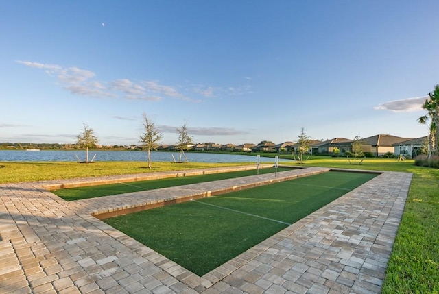 view of home's community with a water view and a yard