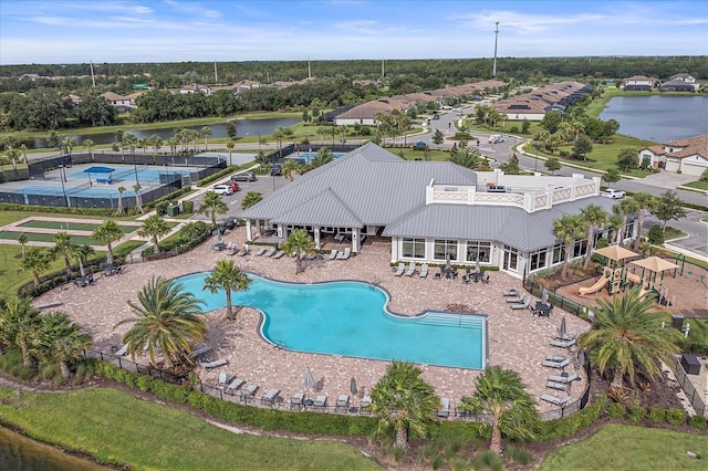 pool featuring a water view and a patio area