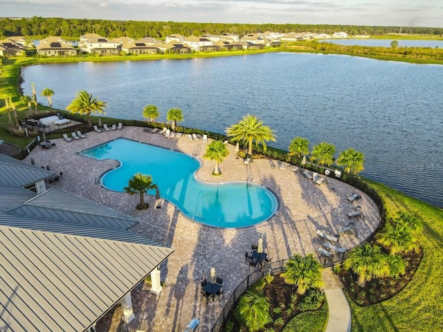 community pool featuring a residential view, a patio area, and a water view