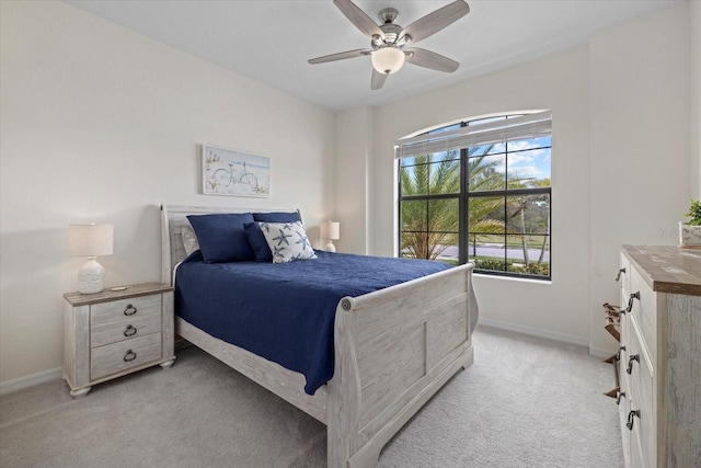 bedroom with light carpet, baseboards, and a ceiling fan