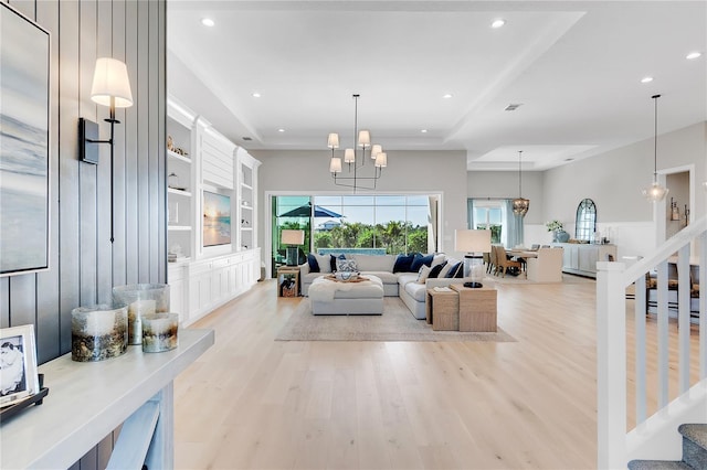 living room featuring a raised ceiling, stairs, light wood-style floors, built in shelves, and recessed lighting