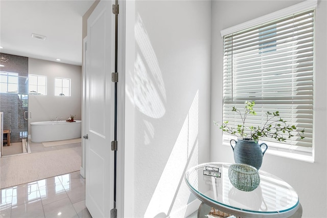 interior space featuring a freestanding tub, visible vents, and tile patterned floors