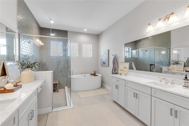 full bathroom featuring a freestanding tub, two vanities, a sink, and a shower stall