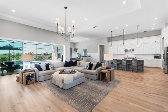 living room with a chandelier, recessed lighting, visible vents, and light wood-style floors