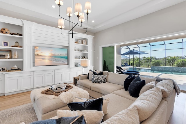 living room featuring light wood finished floors, built in features, a sunroom, a notable chandelier, and recessed lighting