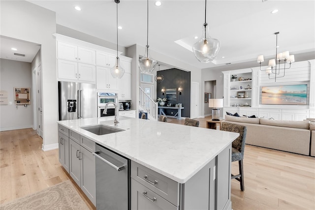 kitchen featuring recessed lighting, gray cabinets, appliances with stainless steel finishes, a sink, and light wood-type flooring