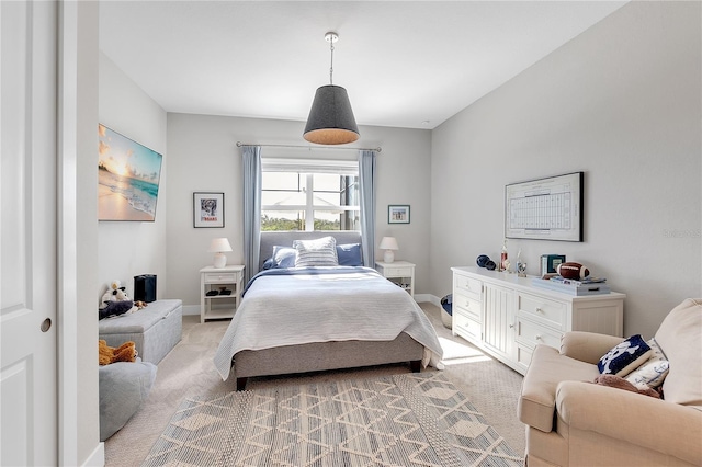 bedroom featuring light carpet and baseboards