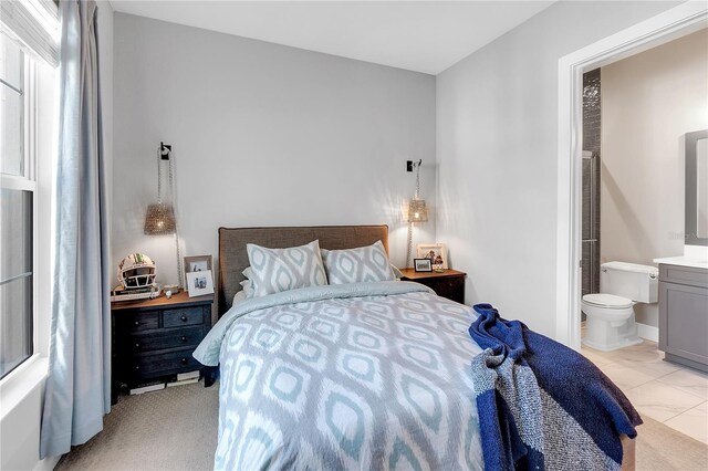 bedroom featuring marble finish floor and ensuite bath