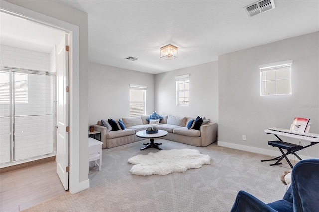 carpeted living area featuring visible vents and baseboards