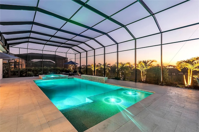 pool at dusk featuring a lanai, a pool with connected hot tub, and a patio