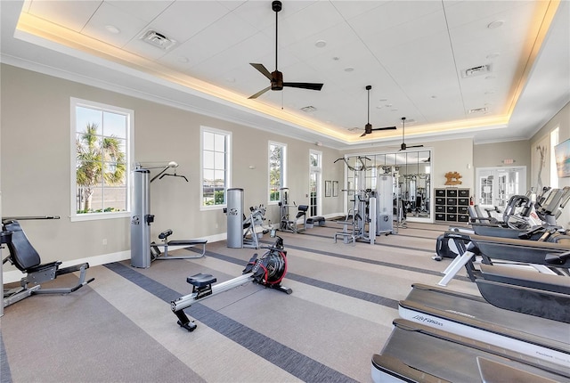 gym featuring a raised ceiling, visible vents, and baseboards