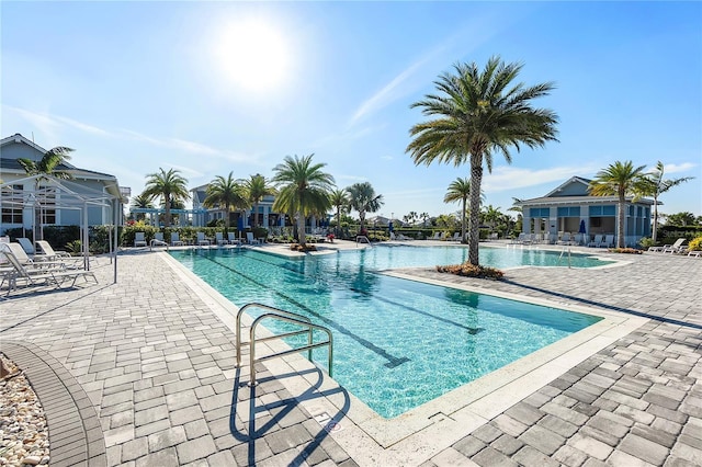 pool with a patio area and fence