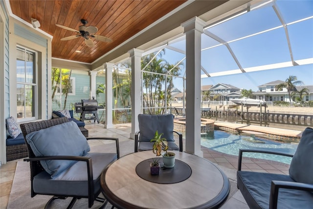 sunroom / solarium featuring wooden ceiling, decorative columns, and ceiling fan