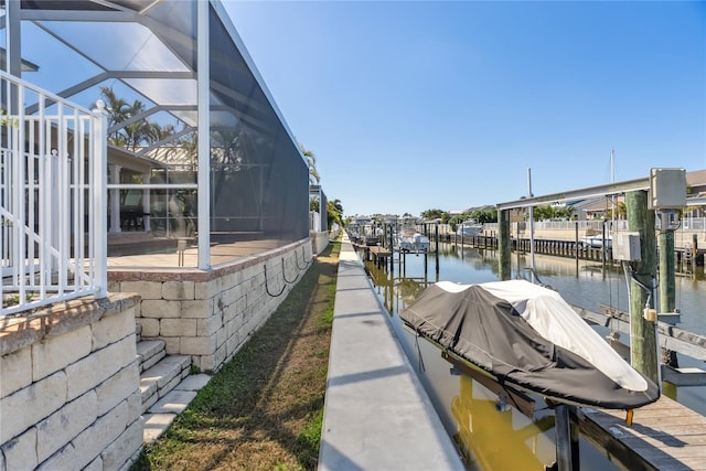 dock area with a lanai, a water view, and boat lift