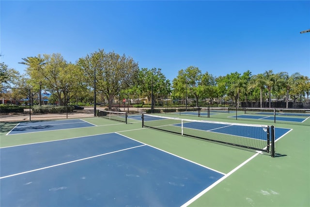 view of tennis court with community basketball court and fence