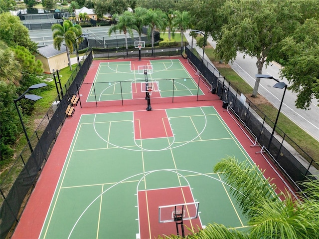 view of sport court featuring a tennis court, community basketball court, and fence