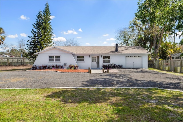 ranch-style house featuring a garage, stucco siding, fence, and a front yard