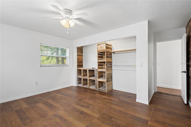 unfurnished bedroom featuring ceiling fan, a closet, hardwood / wood-style flooring, and baseboards