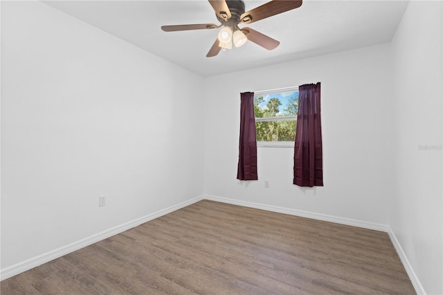 spare room featuring a ceiling fan, baseboards, and wood finished floors