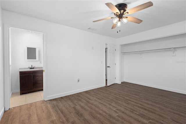 unfurnished bedroom featuring light wood finished floors, visible vents, baseboards, and a sink