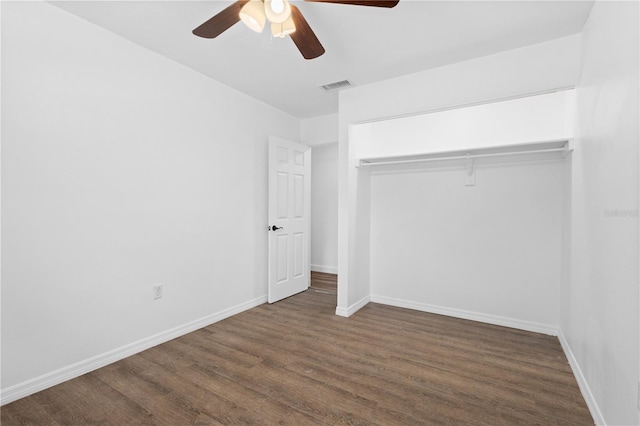 unfurnished bedroom with baseboards, visible vents, ceiling fan, wood finished floors, and a closet