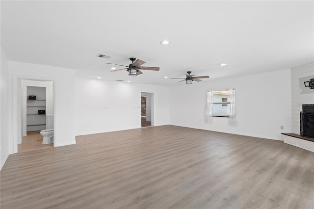 unfurnished living room featuring recessed lighting, a fireplace, visible vents, baseboards, and light wood-style floors