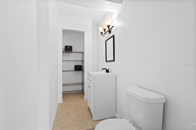 bathroom featuring tile patterned flooring, baseboards, vanity, and toilet