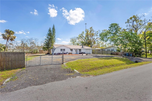 single story home with driveway, a garage, a fenced front yard, a gate, and a front yard