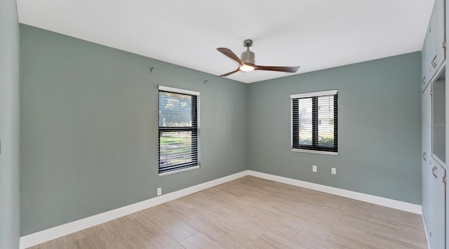 spare room featuring light wood-style floors, ceiling fan, and baseboards