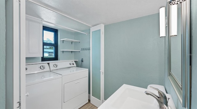 washroom with a sink and washing machine and clothes dryer