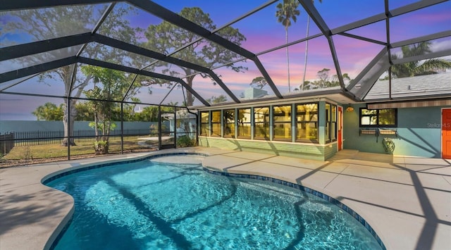 pool at dusk featuring a fenced in pool, glass enclosure, a patio, and fence