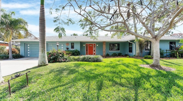 single story home featuring concrete driveway, a front lawn, an attached garage, and stucco siding