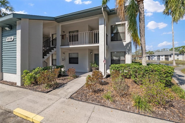 exterior space featuring stairway and stucco siding