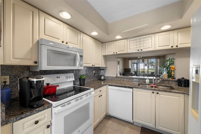 kitchen with white appliances, a sink, light tile patterned flooring, backsplash, and recessed lighting