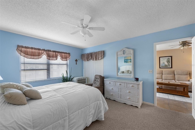 carpeted bedroom with ceiling fan, baseboards, a textured ceiling, and tile patterned floors