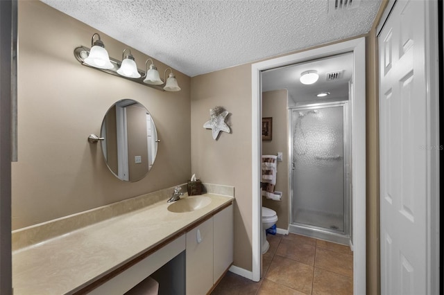 full bath with a textured ceiling, toilet, vanity, a shower stall, and tile patterned floors