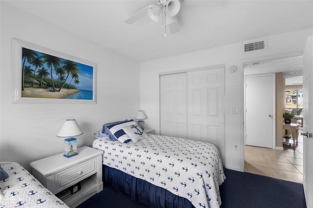 tiled bedroom with ceiling fan, a closet, and visible vents