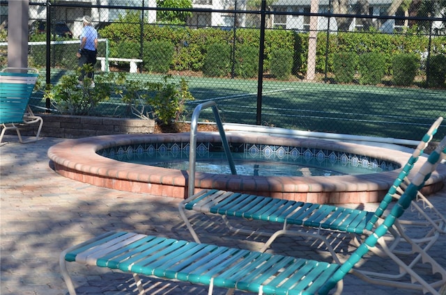 view of pool featuring fence and a community hot tub