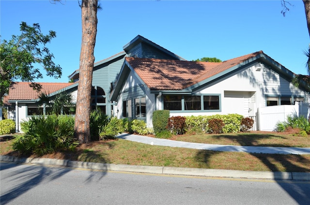 view of front of home featuring fence and a tiled roof